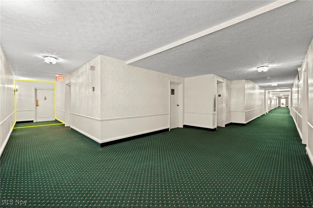 Corridor featuring carpet flooring and a textured ceiling