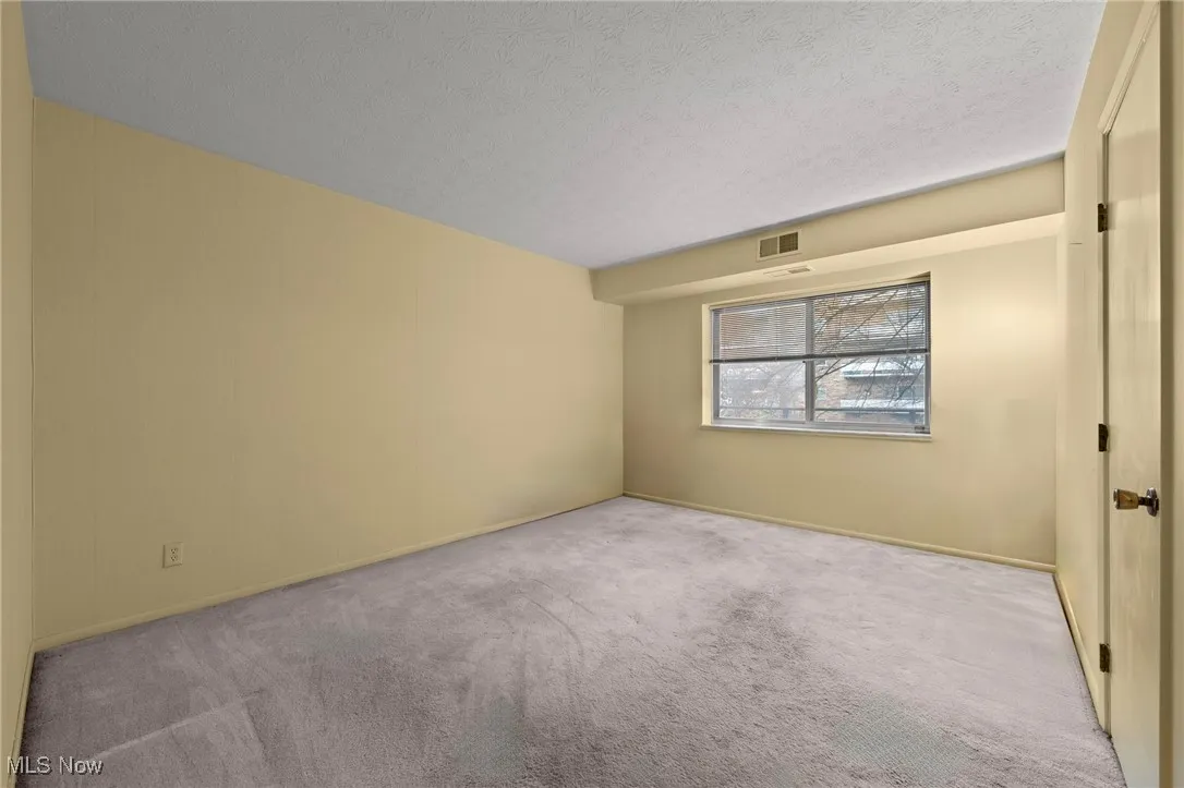 Bedroom with a textured ceiling, carpet, and a view