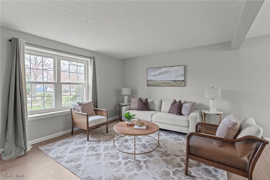 Living area featuring a textured ceiling and light wood-style flooring
