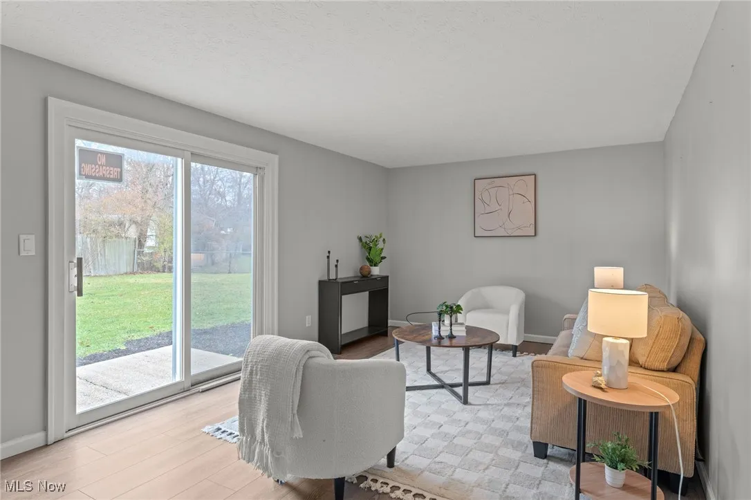 Living area featuring light wood-style floors and a textured ceiling