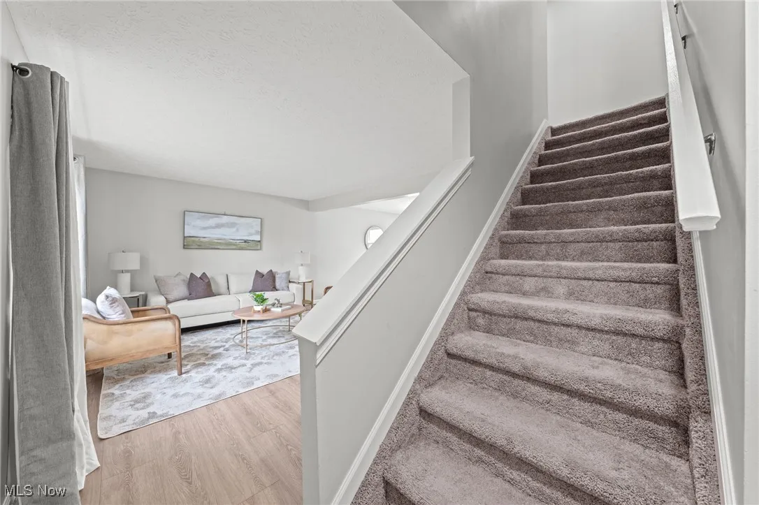 Staircase featuring wood finished floors and a textured ceiling