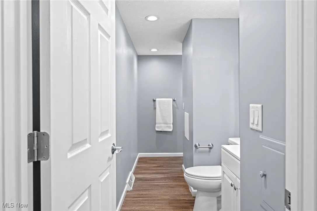 Bathroom featuring vanity, dark wood-type flooring, a textured ceiling, and recessed lighting
