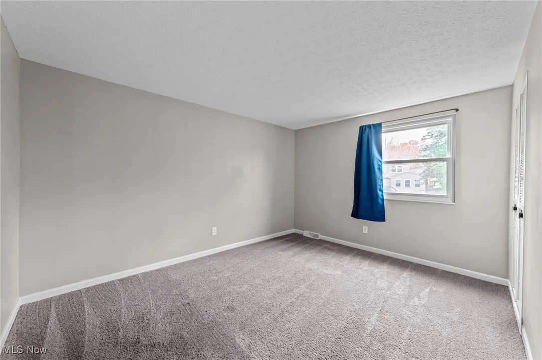 Spare room featuring light carpet and a textured ceiling