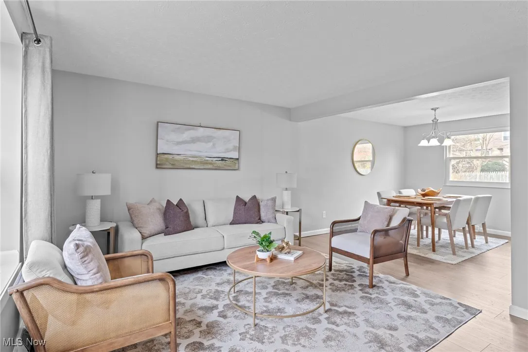 Living area featuring wood finished floors, a chandelier, and a textured ceiling