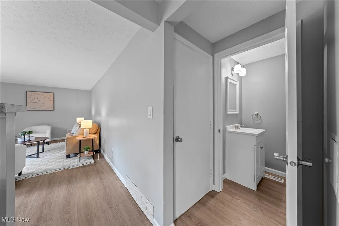 Hall featuring a textured ceiling and light wood-type flooring