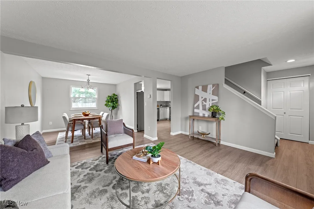 Living area featuring a textured ceiling, wood finished floors, and stairs