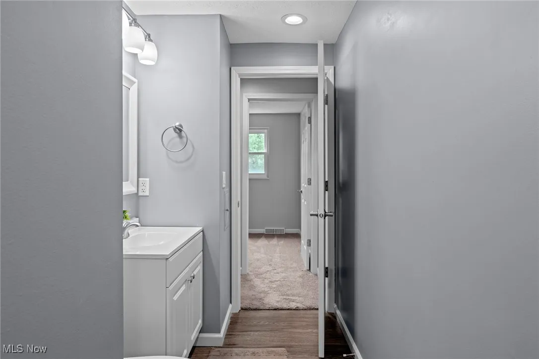 Bathroom with vanity, dark wood-style flooring, and a textured ceiling