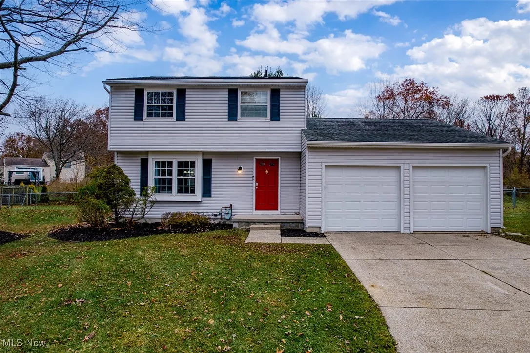 Colonial house featuring an attached garage and concrete driveway