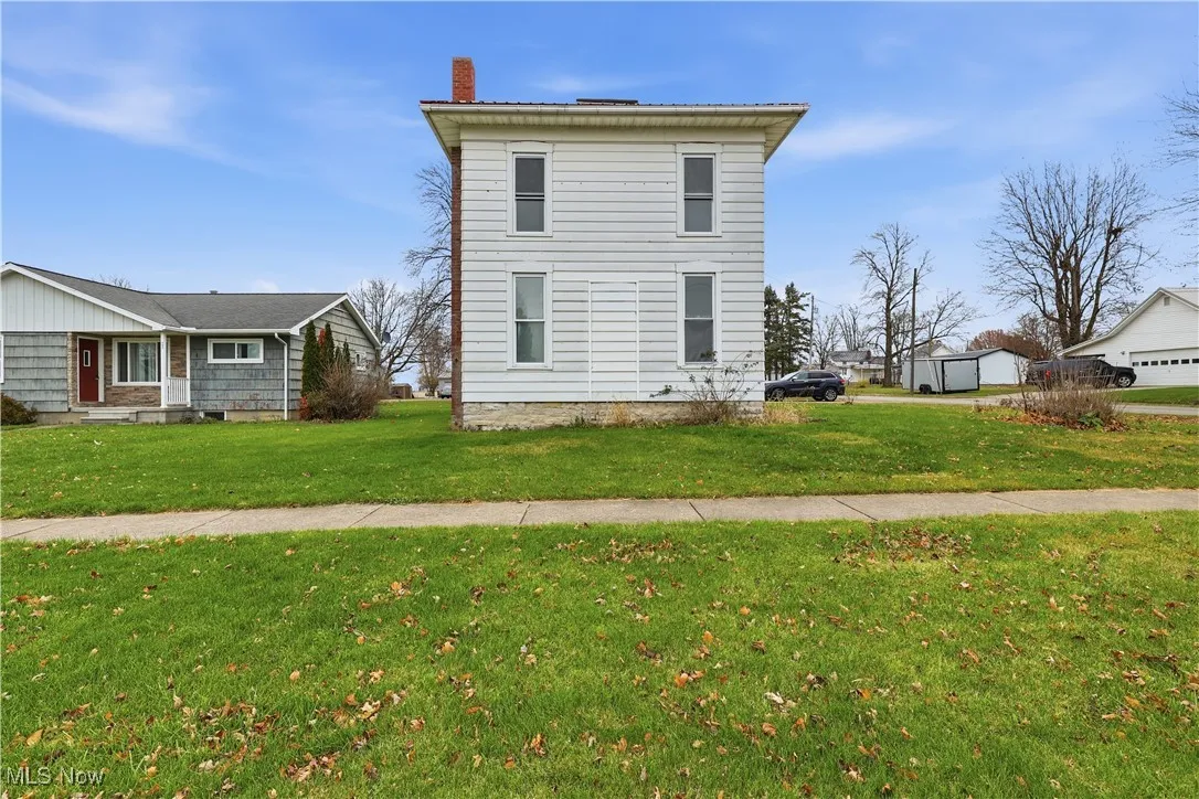 View of side of property with a yard and a chimney