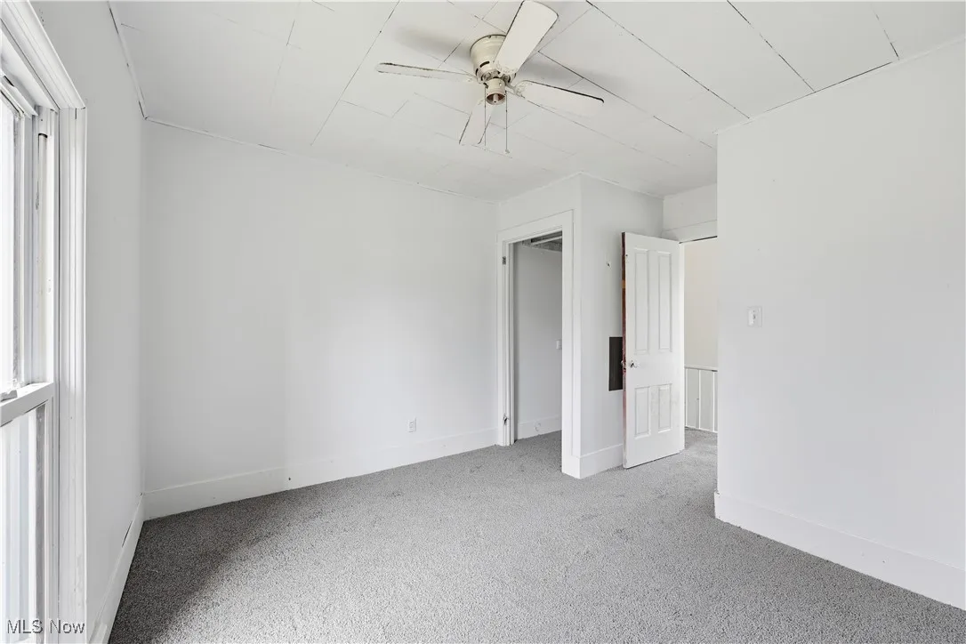 Unfurnished bedroom with carpet floors and a ceiling fan