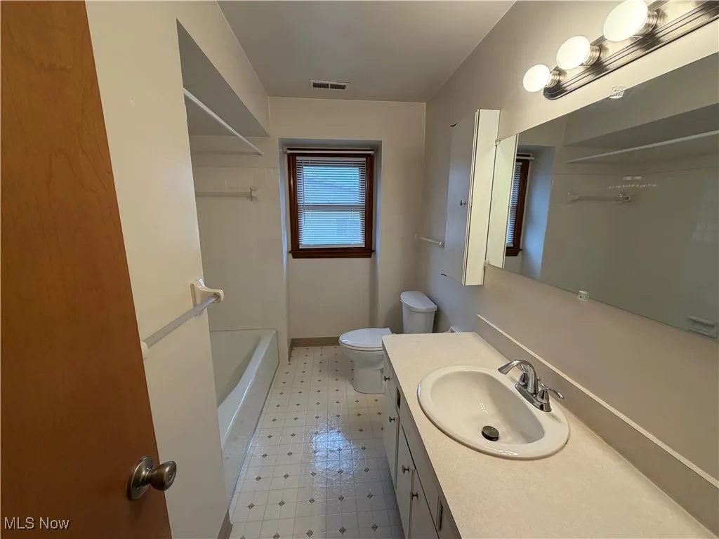 Bathroom with vanity, light flooring, and shower / washtub combination