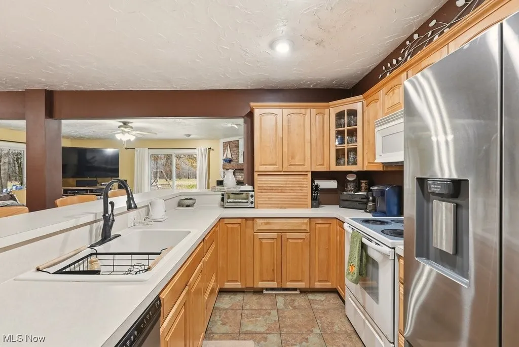 Eat In Kitchen with Breakfast Bar with 4 Chairs, Wood Fireplace, Garbage Disposal, Microwave, Dishwasher, Range, Refrigerator