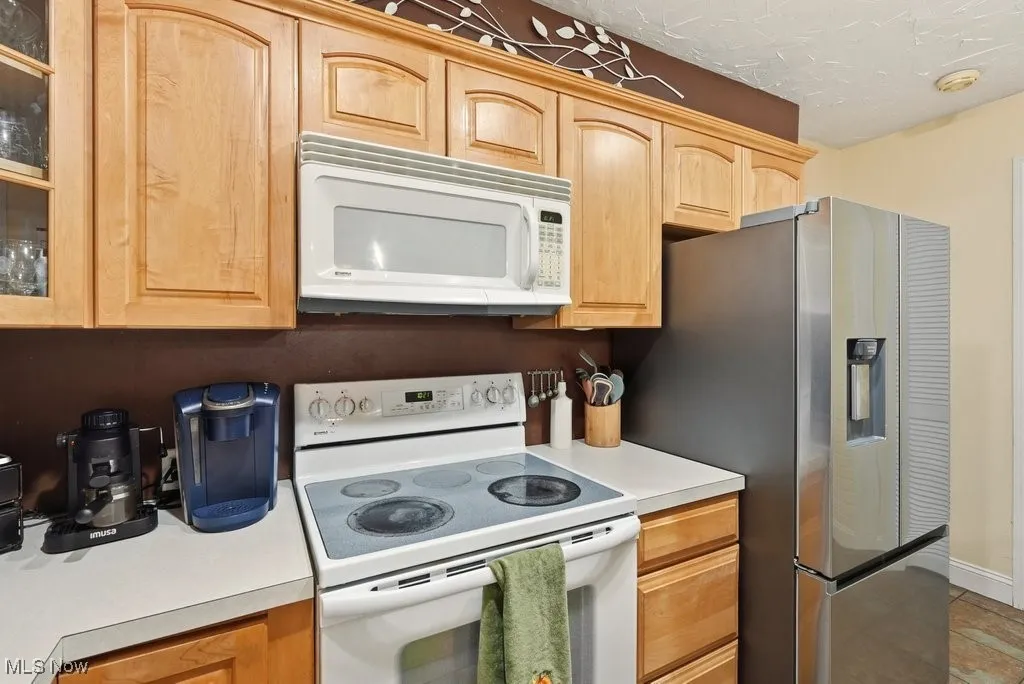 Eat In Kitchen with Breakfast Bar with 4 Chairs, Wood Fireplace, Garbage Disposal, Microwave, Dishwasher, Range, Refrigerator
