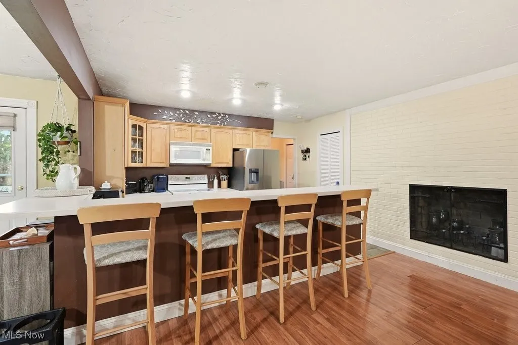 Eat In Kitchen with Breakfast Bar with 4 Chairs, Wood Fireplace, Garbage Disposal, Microwave, Dishwasher, Range, Refrigerator