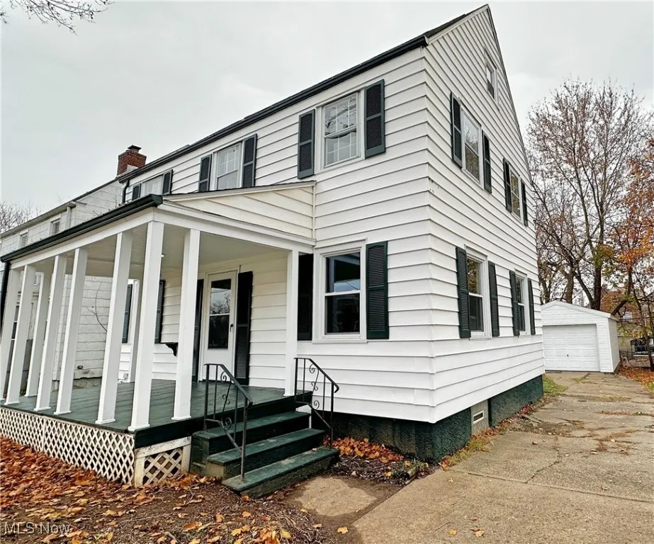 Side of home with view of garage
