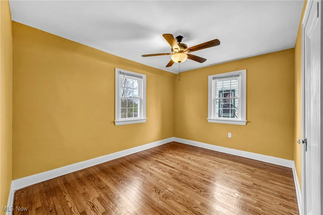Unfurnished room featuring hardwood / wood-style floors and ceiling fan