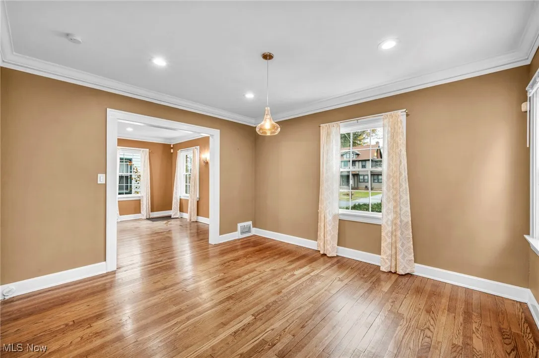 Unfurnished dining area featuring crown molding, light wood finished floors, and recessed lighting