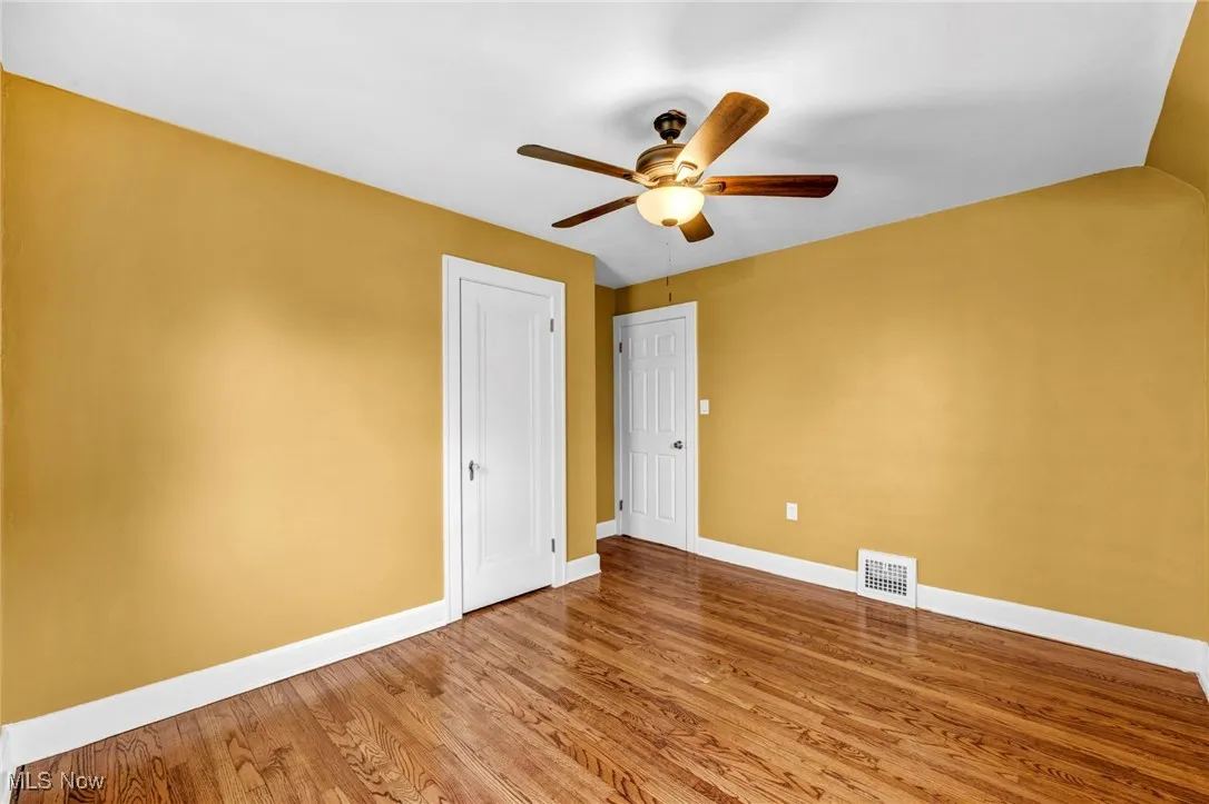Empty room featuring wood finished floors and a ceiling fan