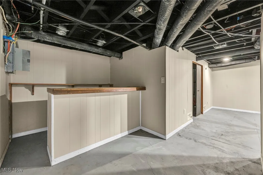 Finished basement with baseboards and wood walls