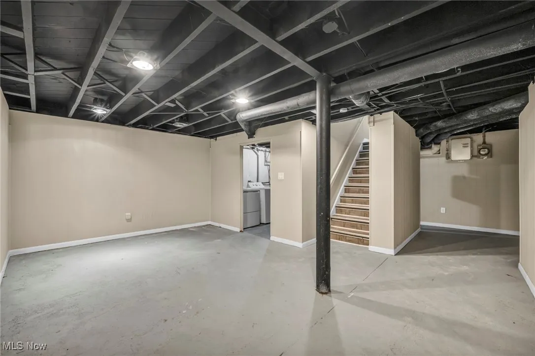 Finished basement featuring stairway and washer and clothes dryer