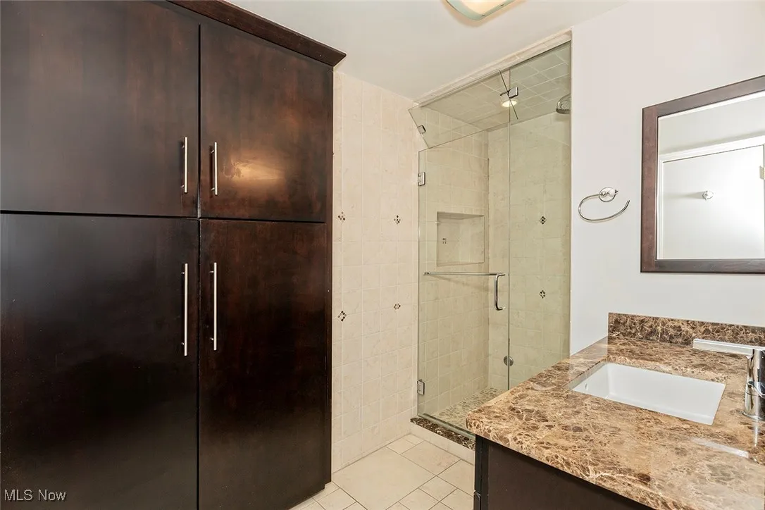 Bathroom with vanity, a stall shower, and light tile patterned flooring