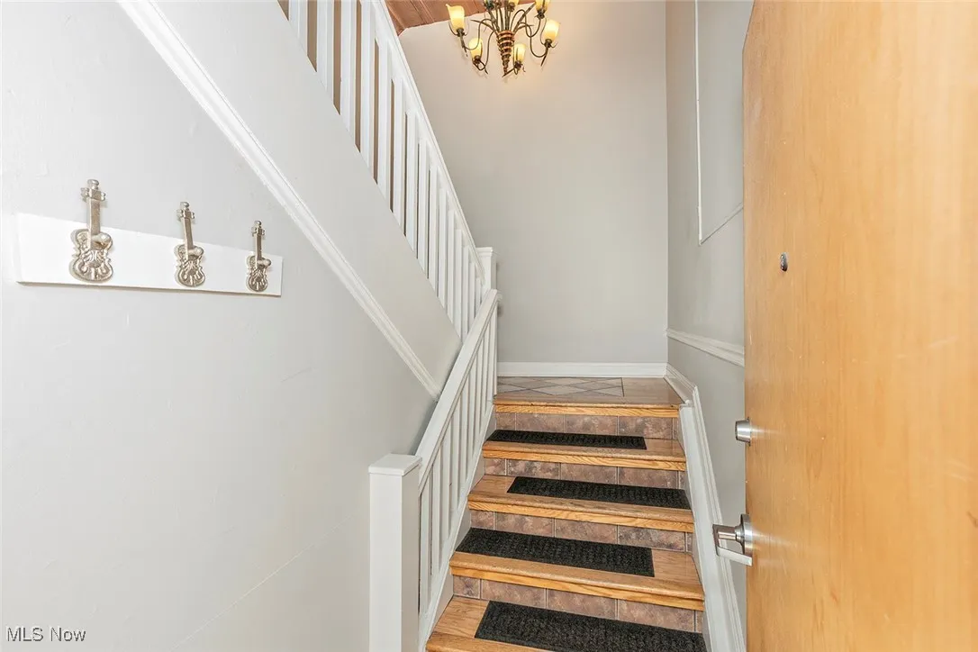 Stairway featuring a chandelier and wood finished floors