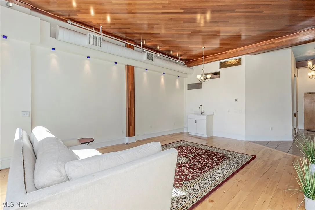 Living room with light wood-type flooring and a chandelier