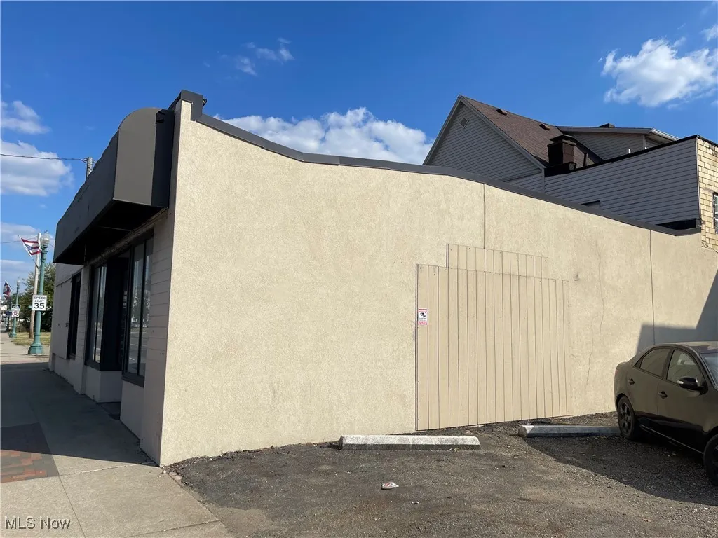 View of home's exterior with stucco siding and uncovered parking