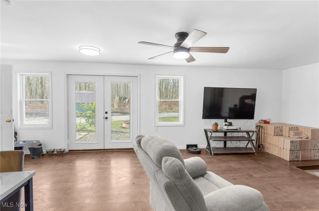 Living room featuring wood finished floors, french doors, and a ceiling fan