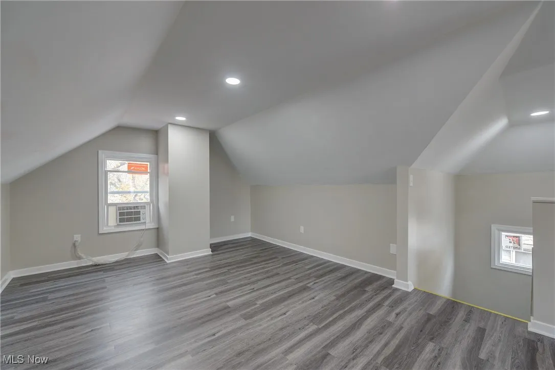 Additional living space featuring lofted ceiling, wood finished floors, and recessed lighting