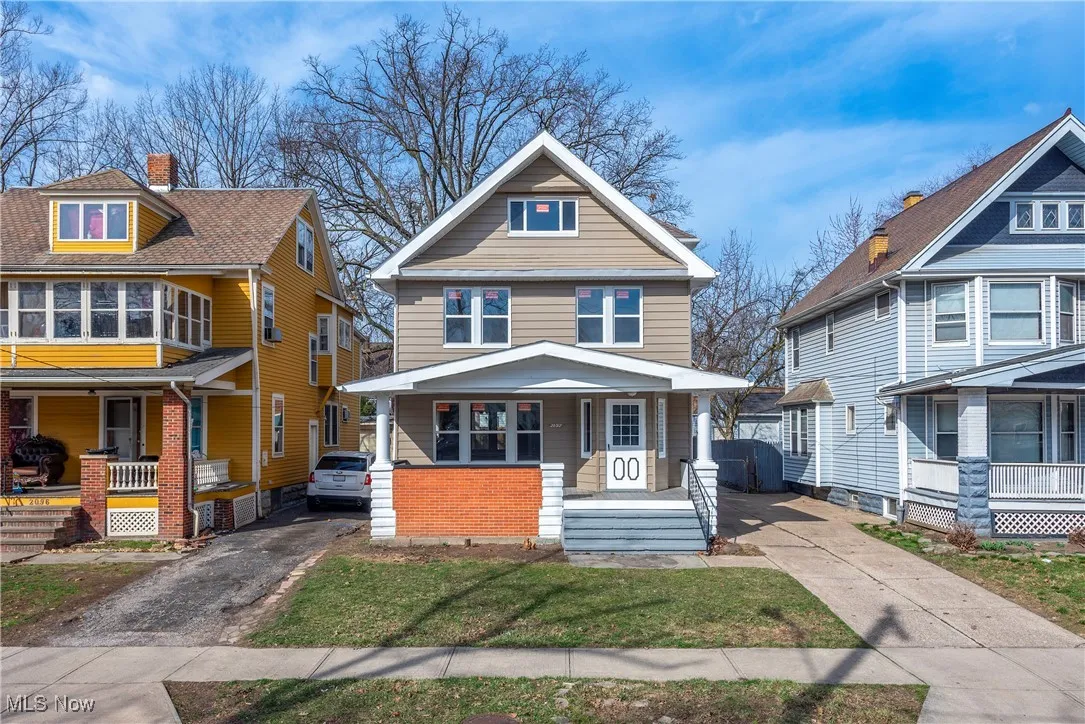 American foursquare style home with a porch and asphalt driveway