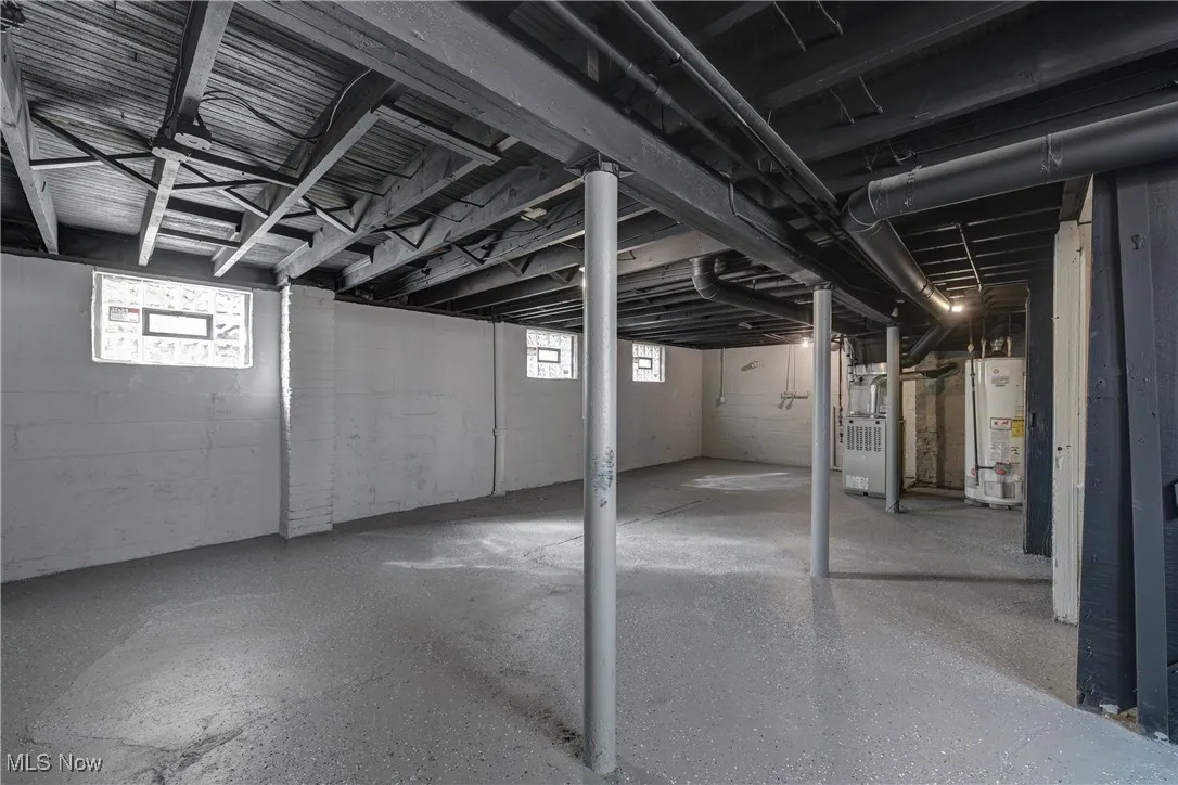 Basement featuring gas water heater, heating unit, and plenty of natural light