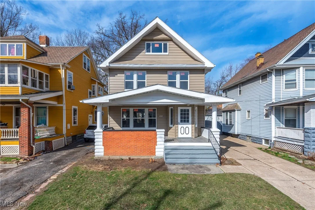 Traditional style home featuring covered porch, a front yard, and driveway