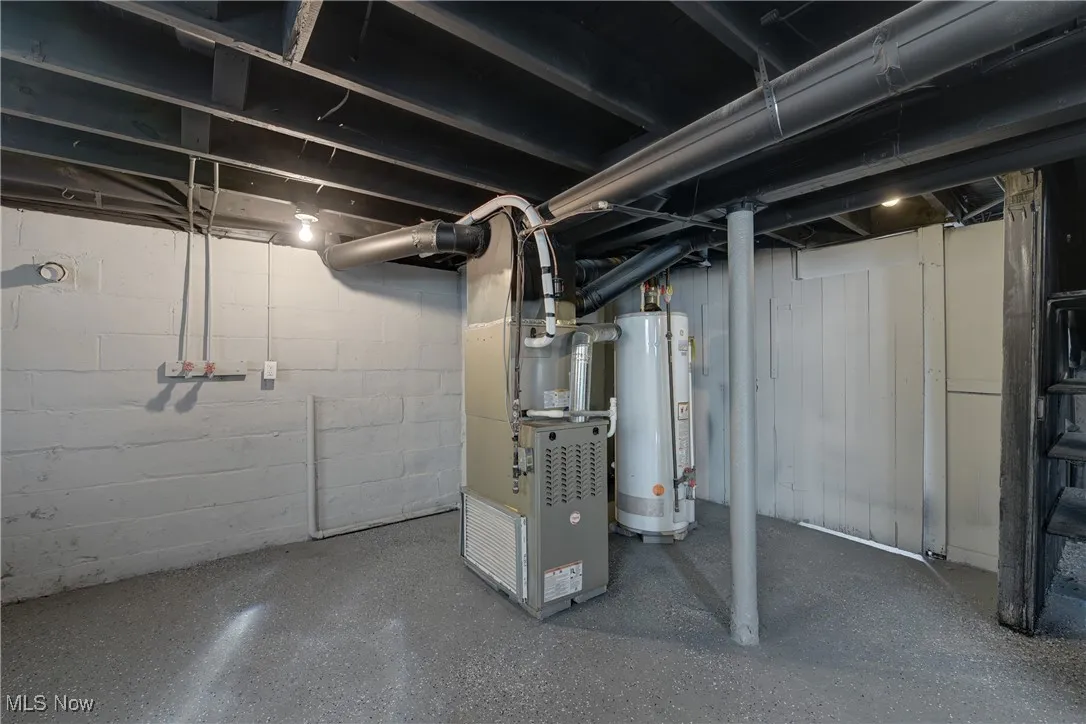 Unfinished basement featuring water heater and heating unit