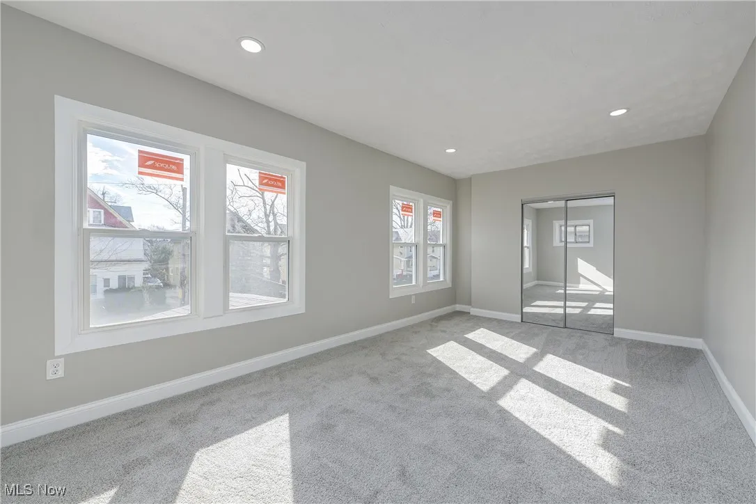 Carpeted spare room featuring baseboards and recessed lighting