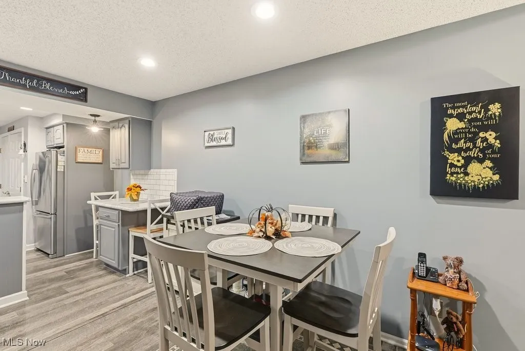 Dining room with recessed lighting, a textured ceiling, and light wood finished floors