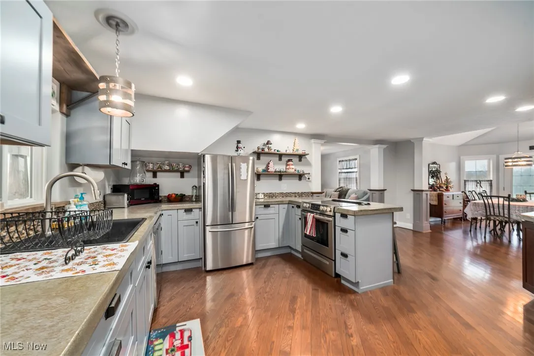 Kitchen with decorative light fixtures, plenty of natural light, stainless steel appliances, and recessed lighting