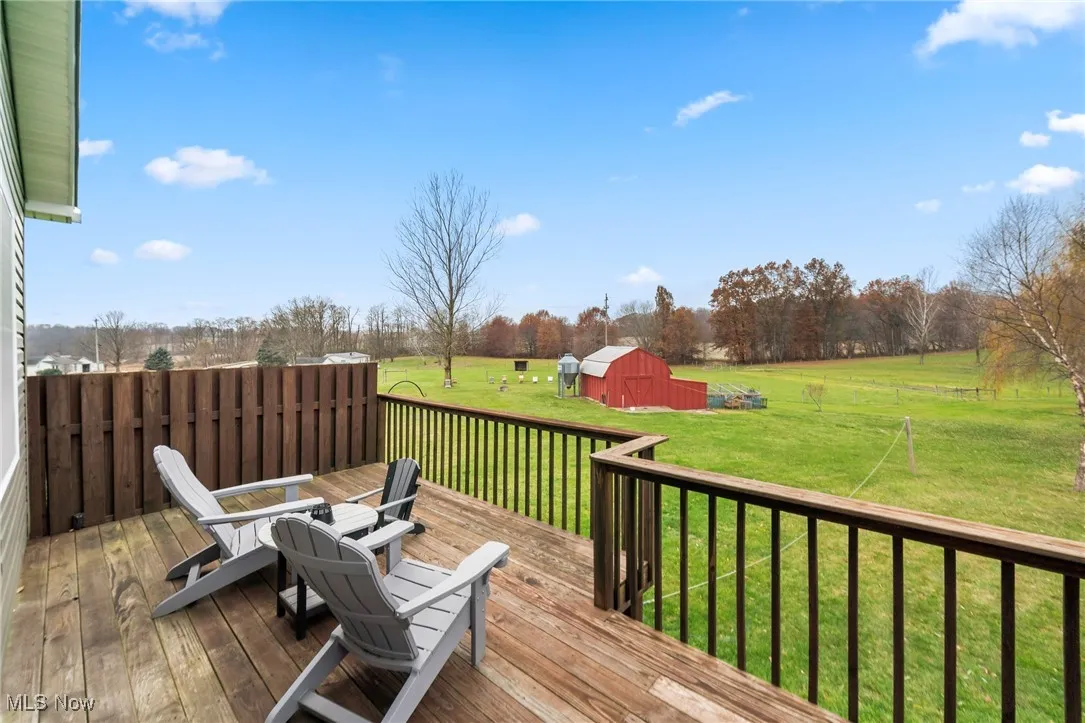 Deck with a yard, a shed, a view of countryside, and view of wooded area