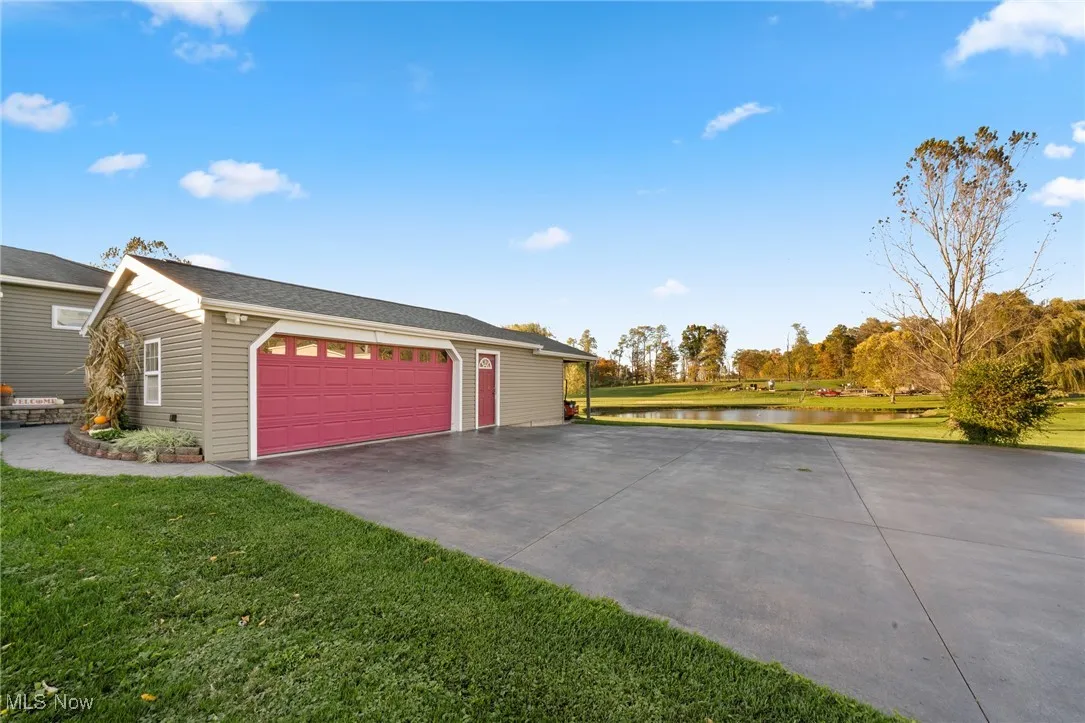 View of side of property featuring a lawn and a water view