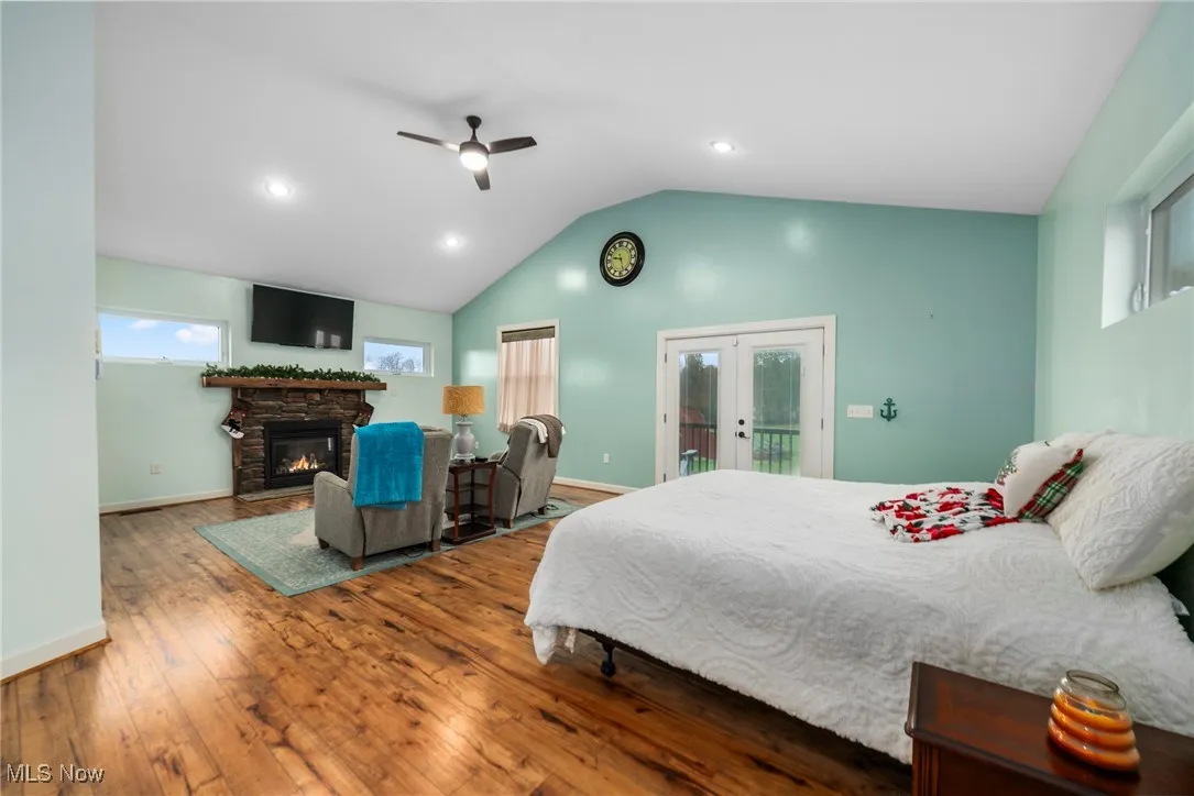 Bedroom with french doors, hardwood / wood-style floors, access to exterior, recessed lighting, and a ceiling fan