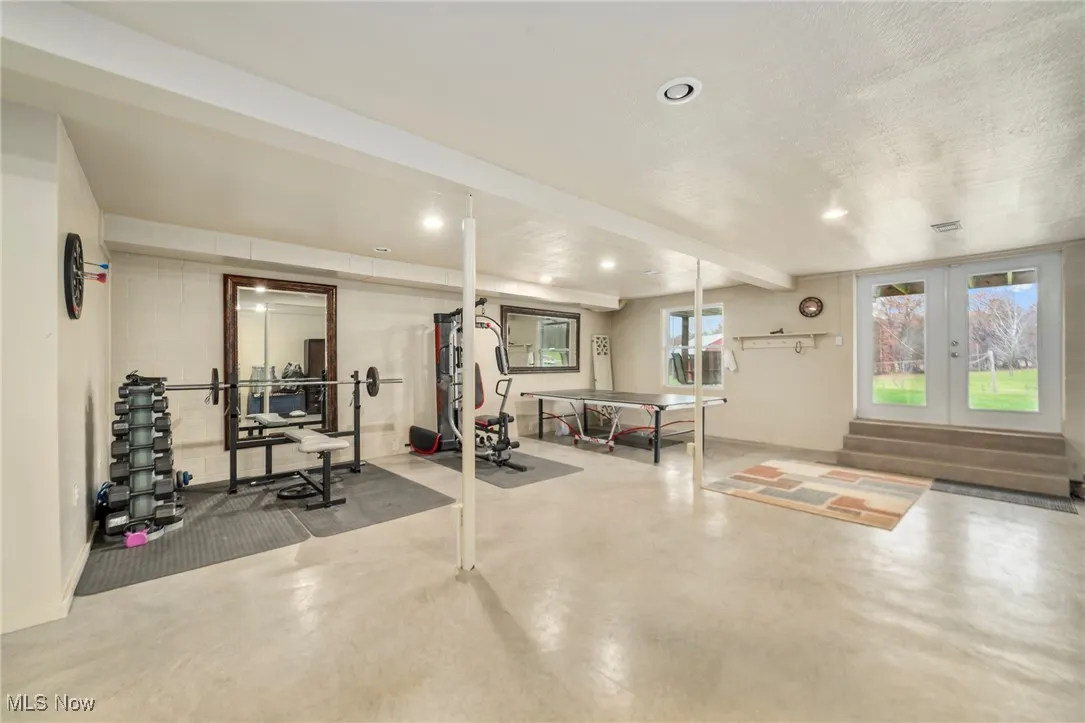 Exercise area with concrete flooring, recessed lighting, and french doors