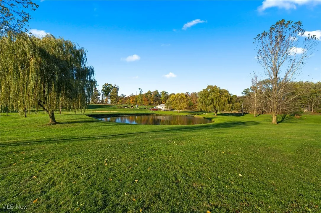 View of property's community with a lawn and a water view