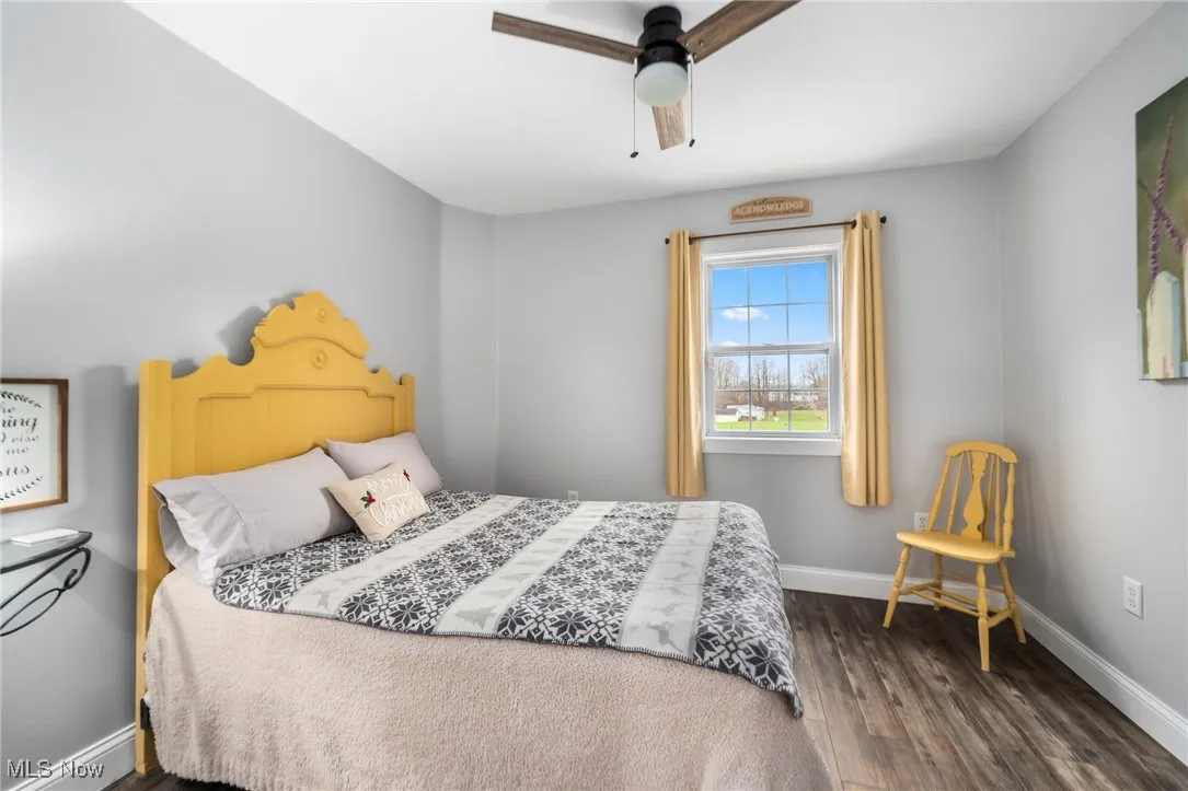 Bedroom with dark wood-style floors and ceiling fan