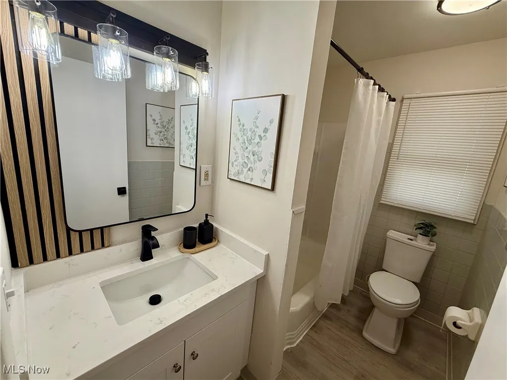 Full bathroom featuring vanity, wood finished floors, and shower / bath combo