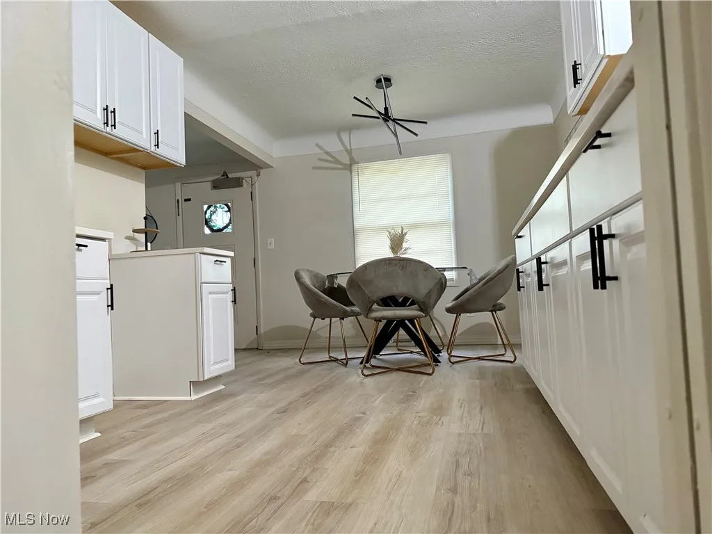 Dining area with a textured ceiling and light wood-style floors