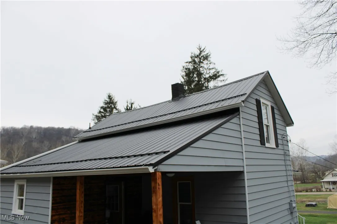 View of home's exterior featuring a metal roof and a chimney