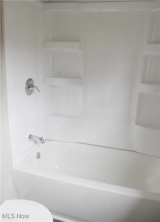 Bathroom featuring tub / shower combination and toilet