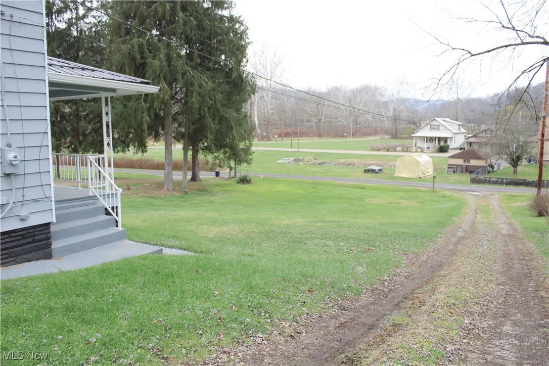 View of green lawn with covered porch