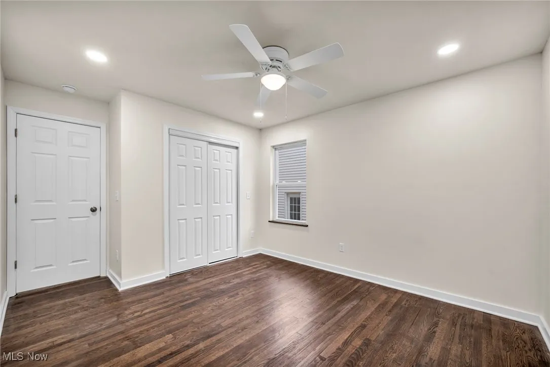Unfurnished bedroom with dark wood-type flooring, a ceiling fan, a closet, and recessed lighting