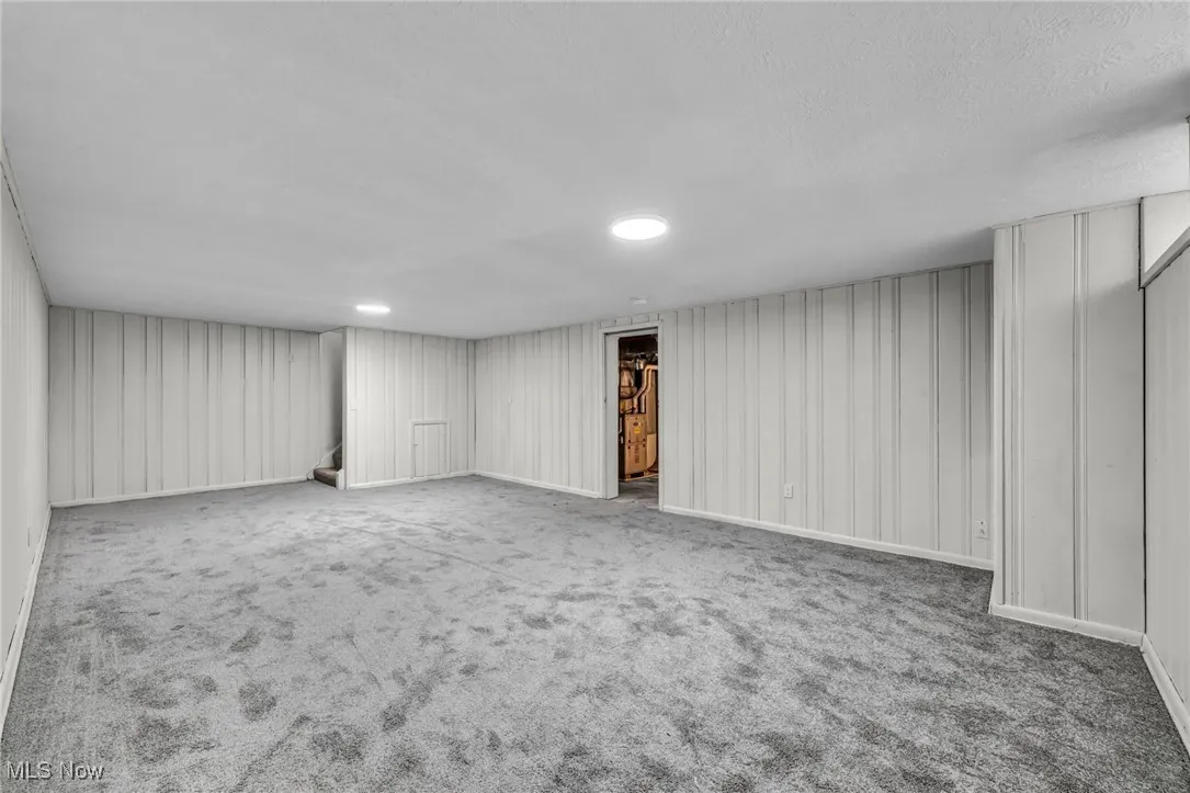 Finished basement featuring stairway and carpet